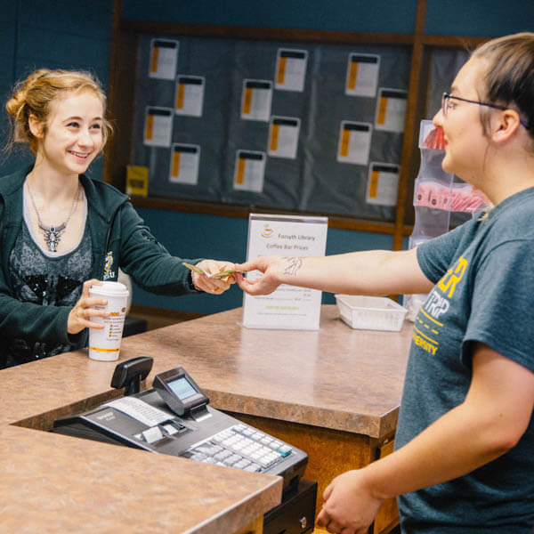 a student buying a cup of coffee at Forsyth Library